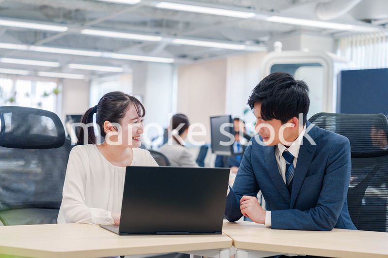 先輩社員から業務を教えてもらう新人の女性