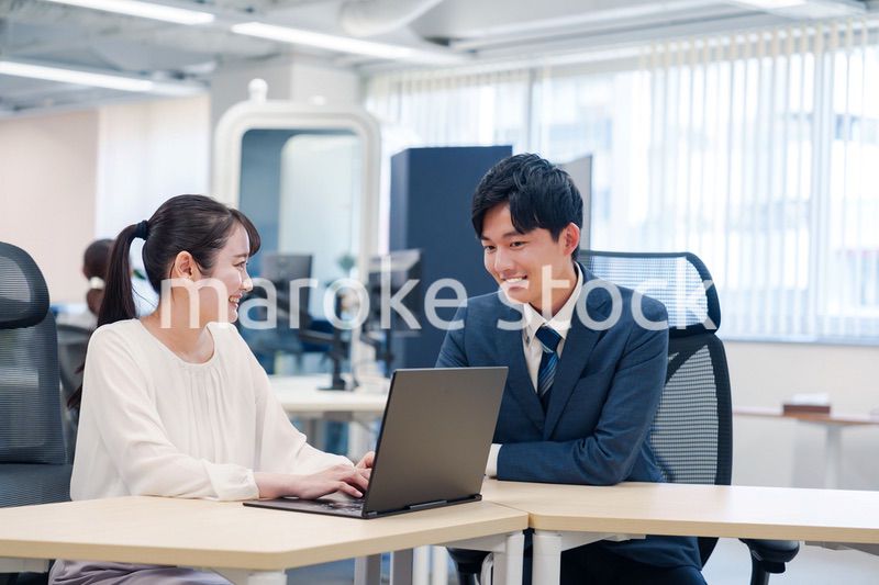 先輩社員から業務を教えてもらう新人の女性