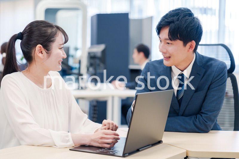 先輩社員から業務を教えてもらう新人の女性