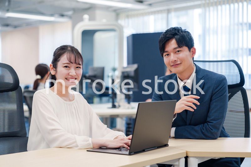 先輩社員から業務を教えてもらう新人の女性