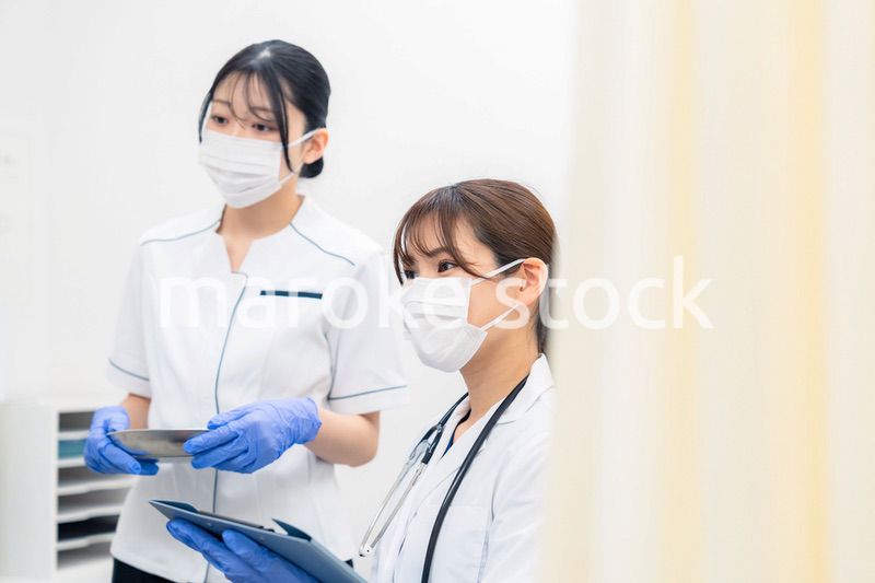 患者の治療をする2人の若い医療従事者