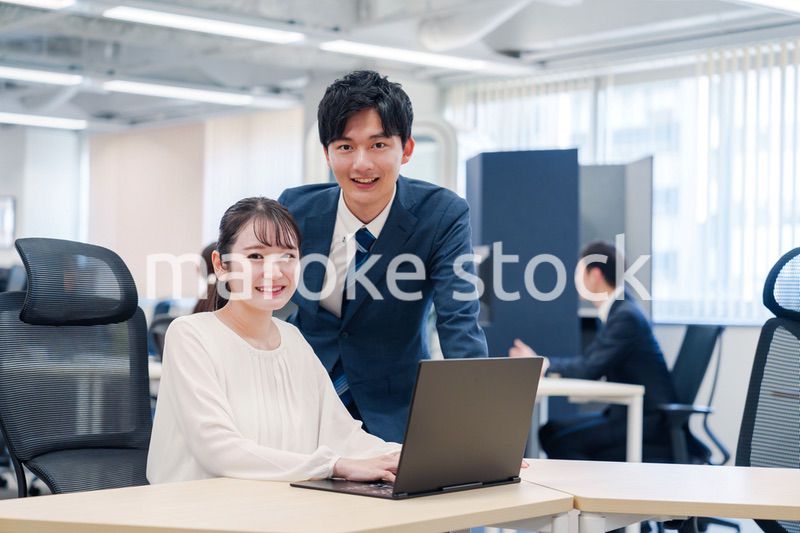 先輩社員から業務を教えてもらう新人の女性