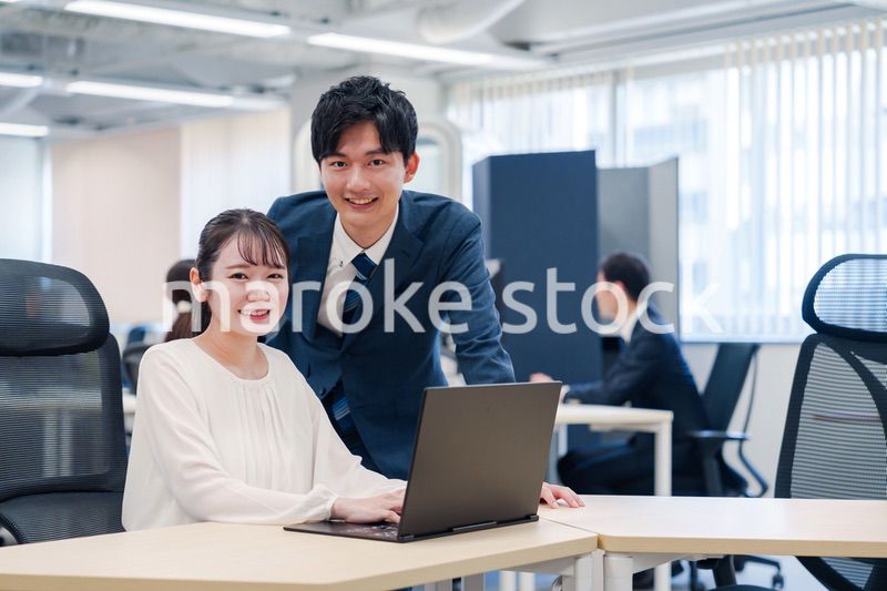 先輩社員から業務を教えてもらう新人の女性