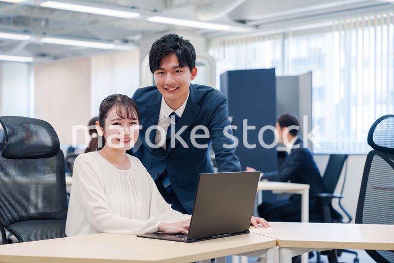 先輩社員から業務を教えてもらう新人の女性