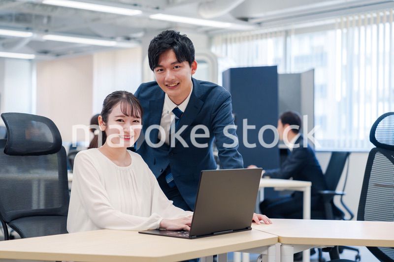 先輩社員から業務を教えてもらう新人の女性