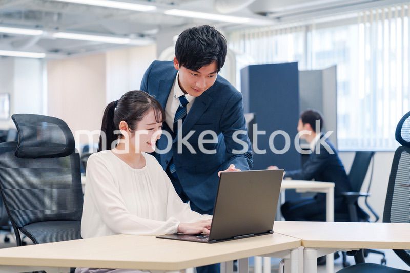 先輩社員から業務を教えてもらう新人の女性