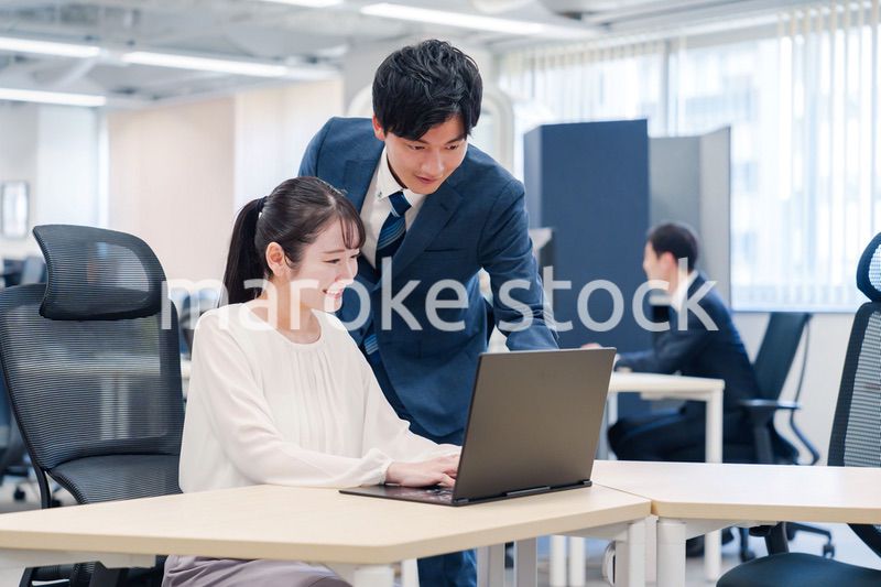 先輩社員から業務を教えてもらう新人の女性