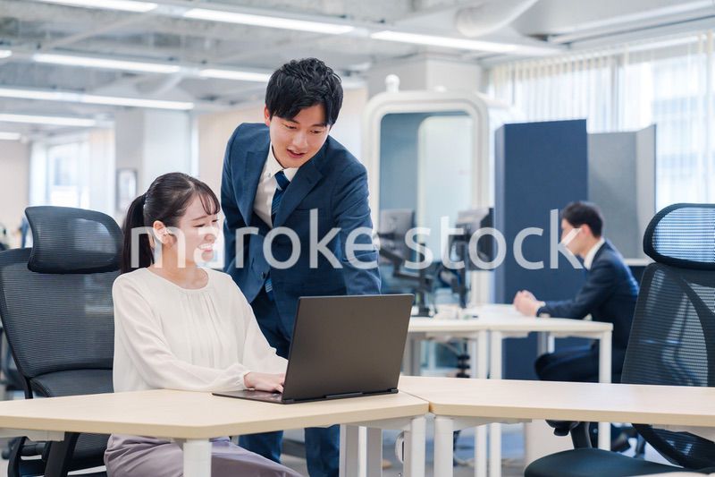 先輩社員から業務を教えてもらう新人の女性