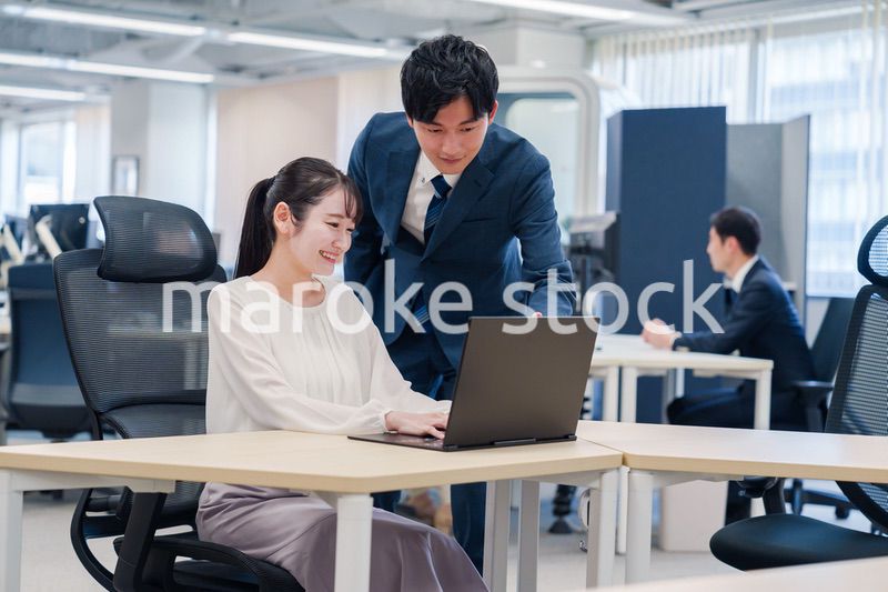 先輩社員から業務を教えてもらう新人の女性