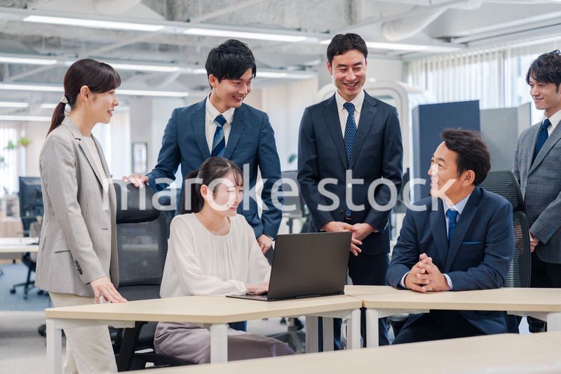 チームメンバーで非常ににこやかに仕事をするオフィスワーカー