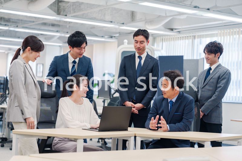 チームメンバーで非常ににこやかに仕事をするオフィスワーカー