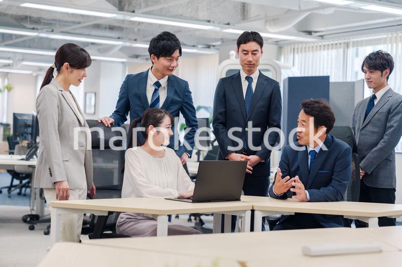 チームメンバーで非常ににこやかに仕事をするオフィスワーカー