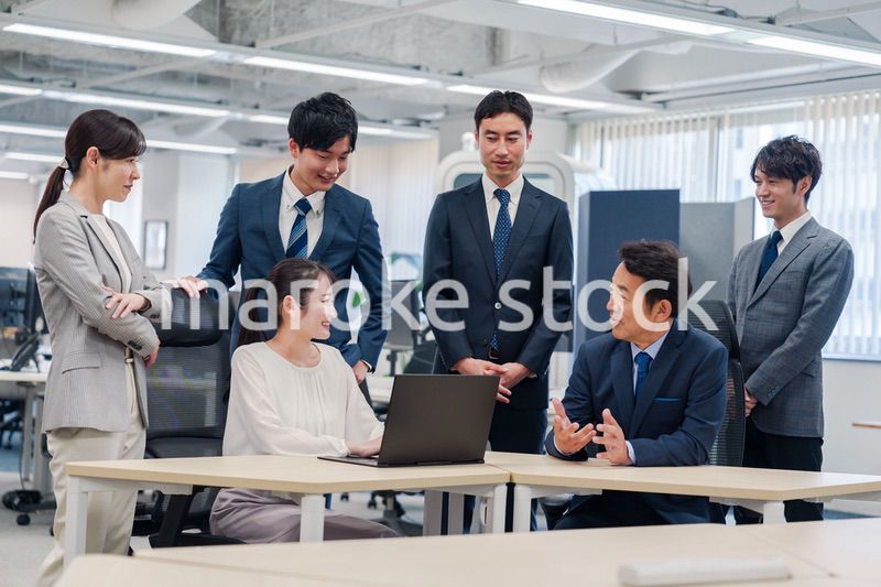 チームメンバーで非常ににこやかに仕事をするオフィスワーカー