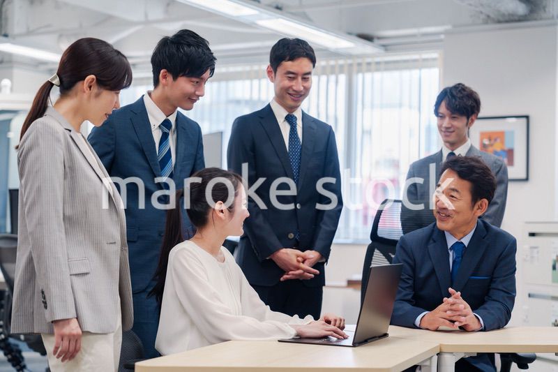 チームメンバーで非常ににこやかに仕事をするオフィスワーカー