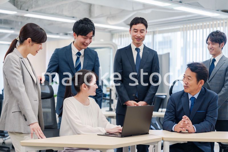 チームメンバーで非常ににこやかに仕事をするオフィスワーカー