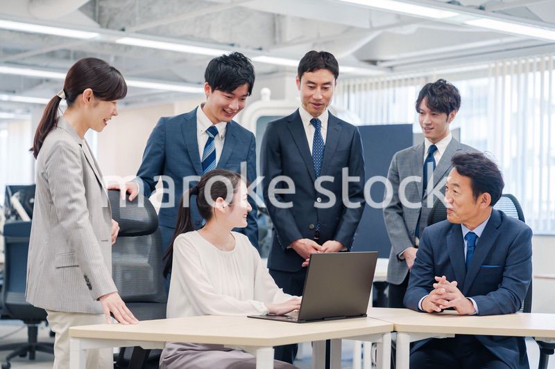 チームメンバーで非常ににこやかに仕事をするオフィスワーカー