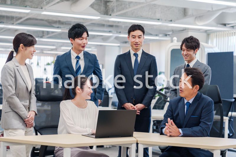 チームメンバーで非常ににこやかに仕事をするオフィスワーカー