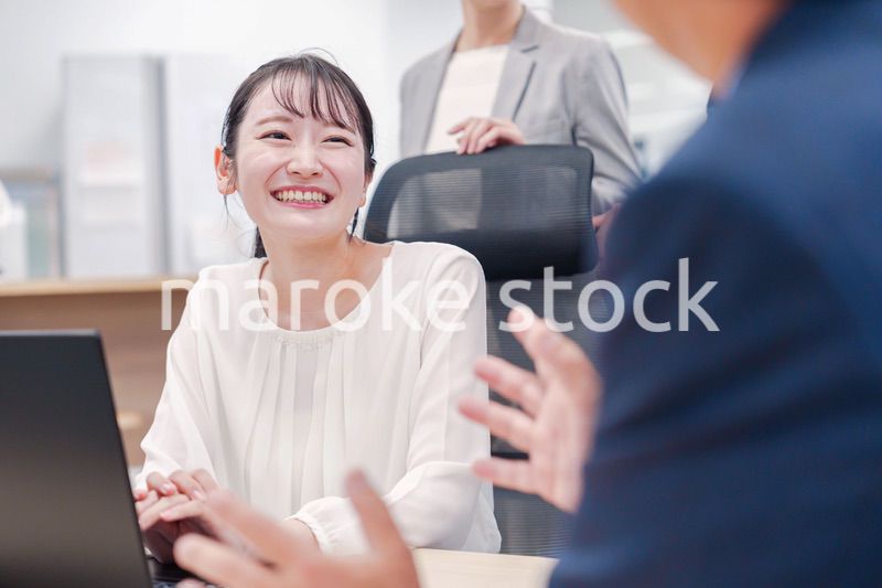 笑顔で上司の話を聞く若いビジネスウーマン