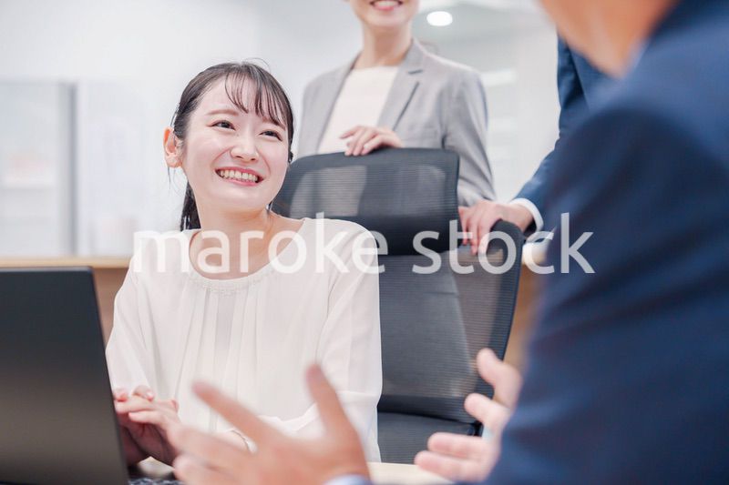 笑顔で上司の話を聞く若いビジネスウーマン