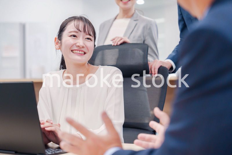 笑顔で上司の話を聞く若いビジネスウーマン