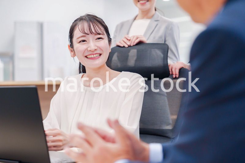 笑顔で上司の話を聞く若いビジネスウーマン