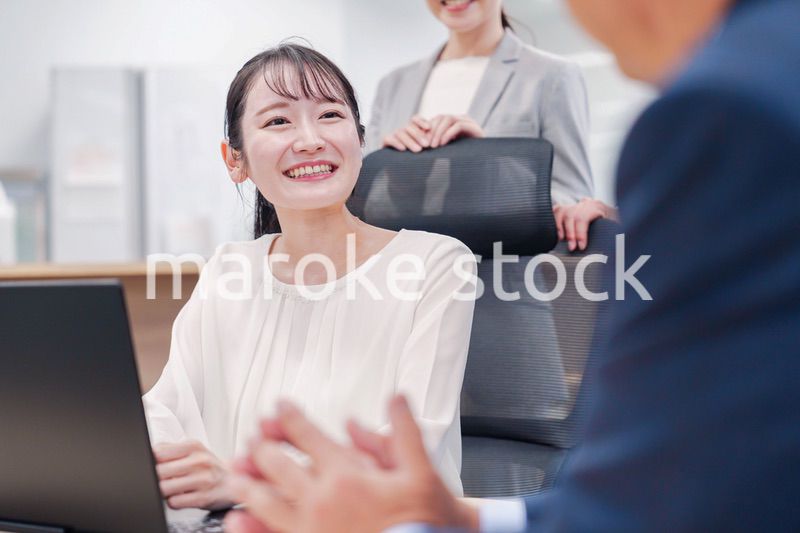 笑顔で上司の話を聞く若いビジネスウーマン