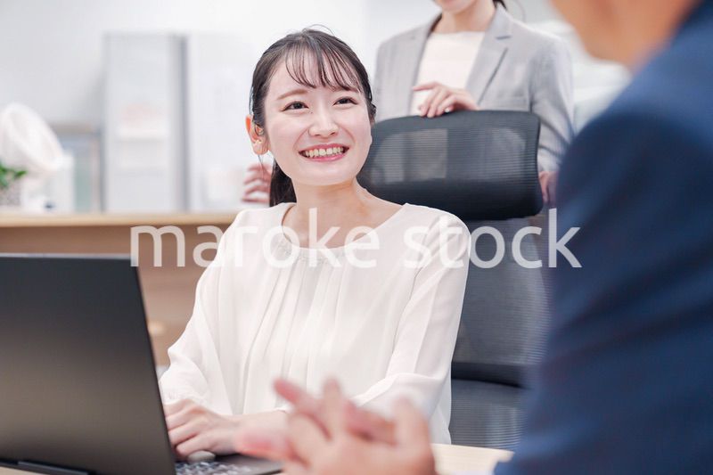 笑顔で上司の話を聞く若いビジネスウーマン