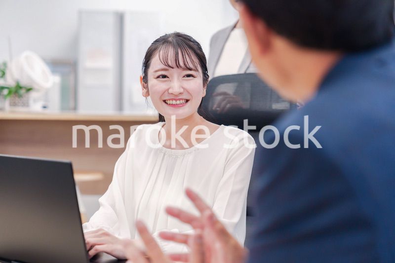 笑顔で上司の話を聞く若いビジネスウーマン