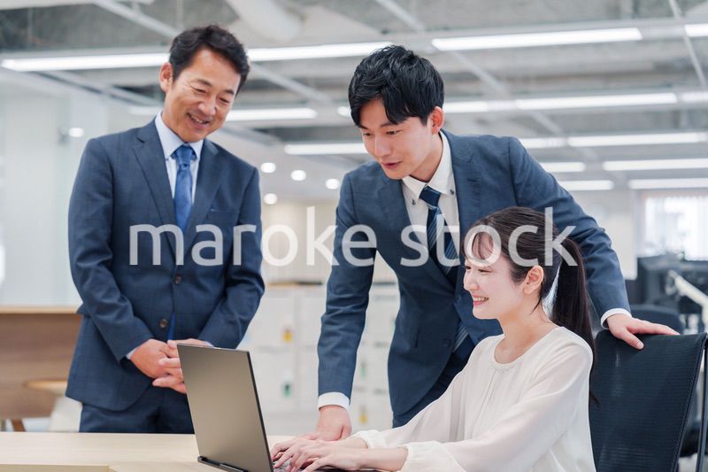 オフィスのデスクで打ち合わせをする男女のビジネスパーソン