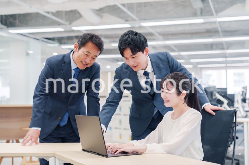 オフィスのデスクで打ち合わせをする男女のビジネスパーソン