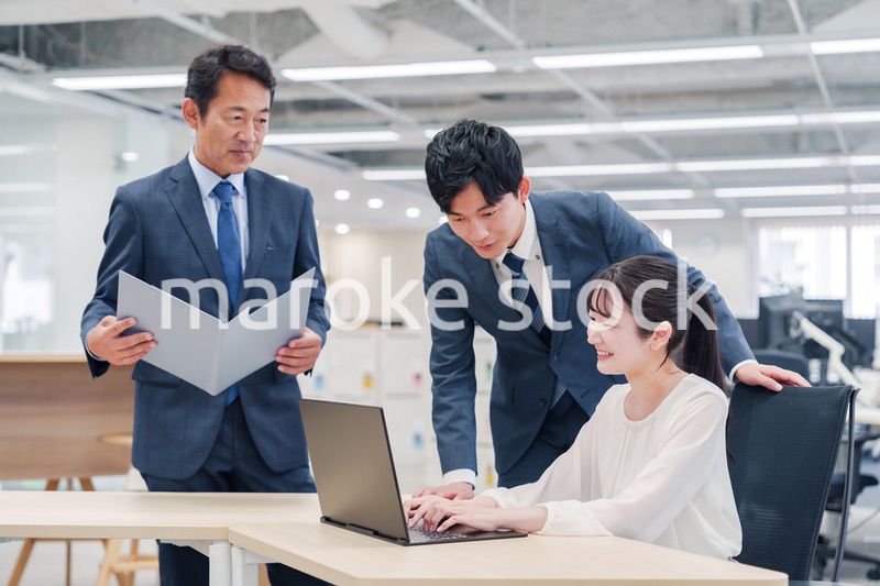 オフィスのデスクで打ち合わせをする男女のビジネスパーソン