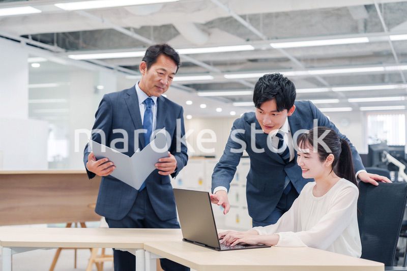 オフィスのデスクで打ち合わせをする男女のビジネスパーソン