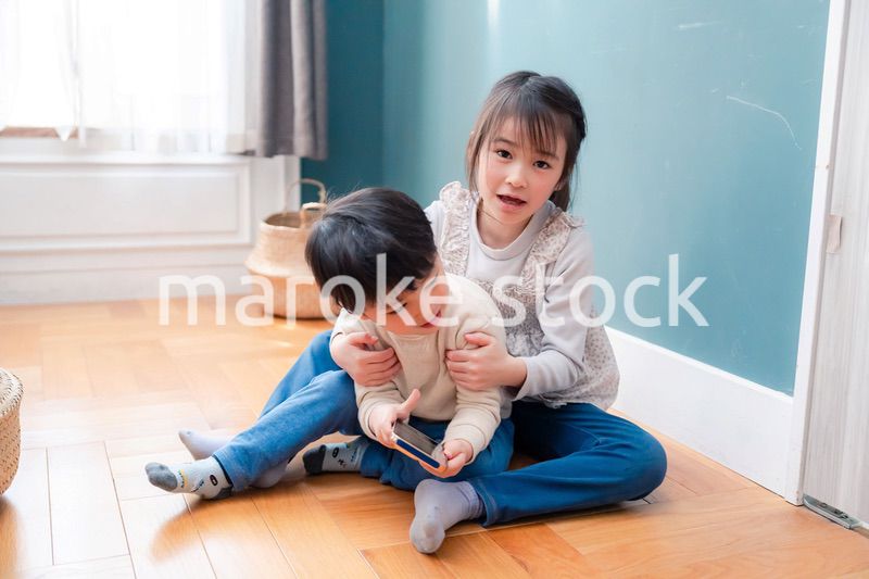 兄弟でスマホを取り合う小さな子ども