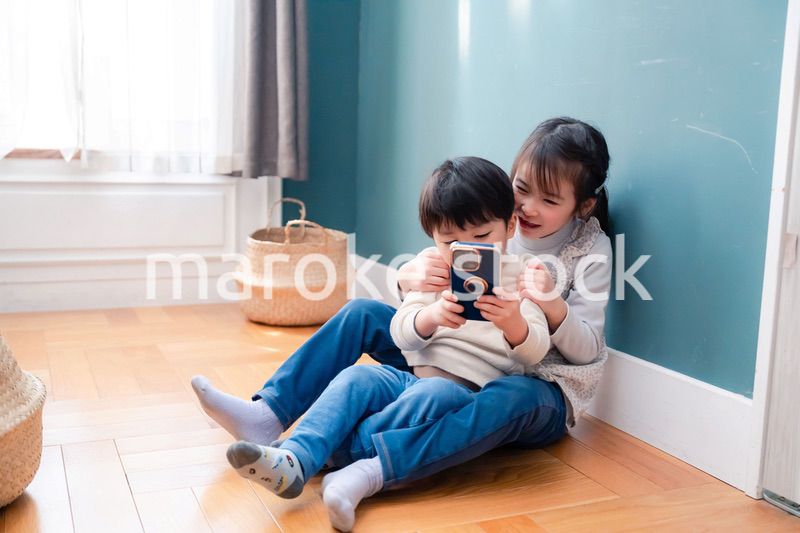 兄弟でスマホを取り合う小さな子ども