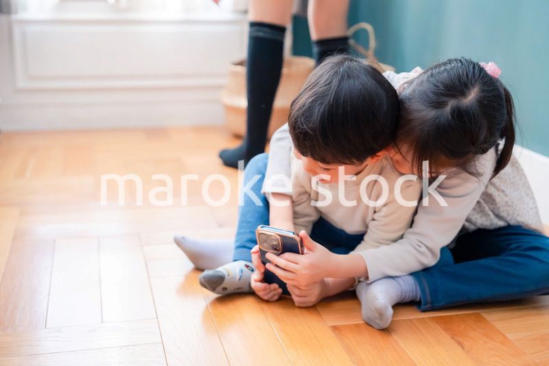 兄弟でスマホを取り合う小さな子ども