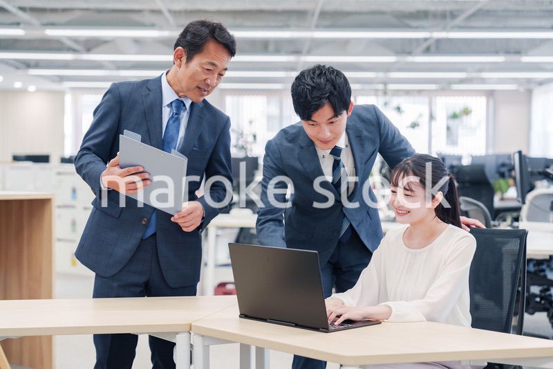 オフィスのデスクで打ち合わせをする男女のビジネスパーソン