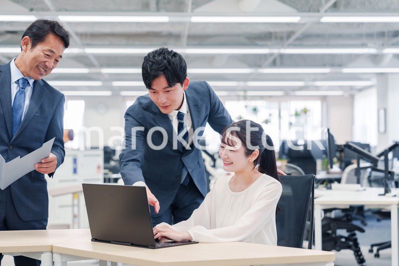 オフィスのデスクで打ち合わせをする男女のビジネスパーソン