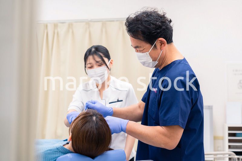 歯科治療をする歯医者の男性