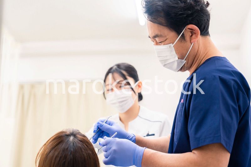 歯科治療をする歯医者の男性