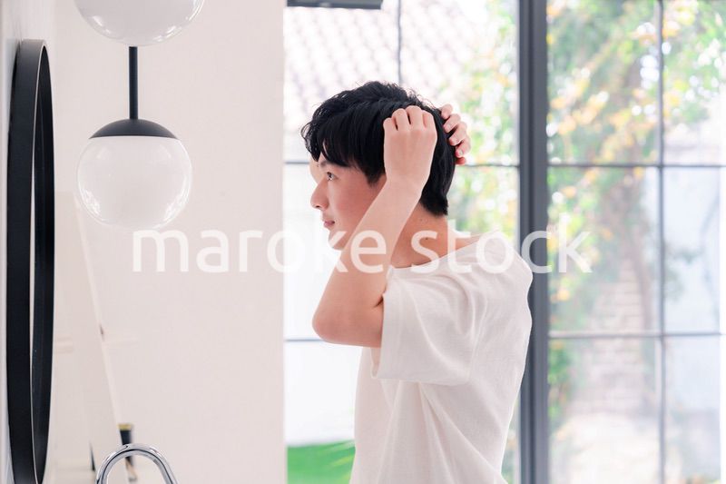 洗面所で身だしなみを整える若い男性
