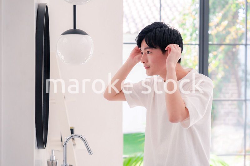 洗面所で身だしなみを整える若い男性