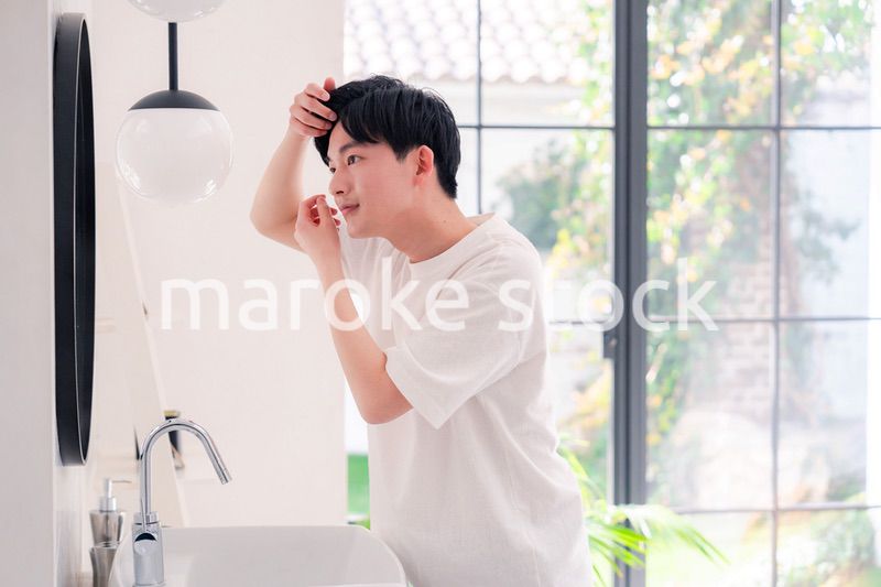 洗面所で身だしなみを整える若い男性