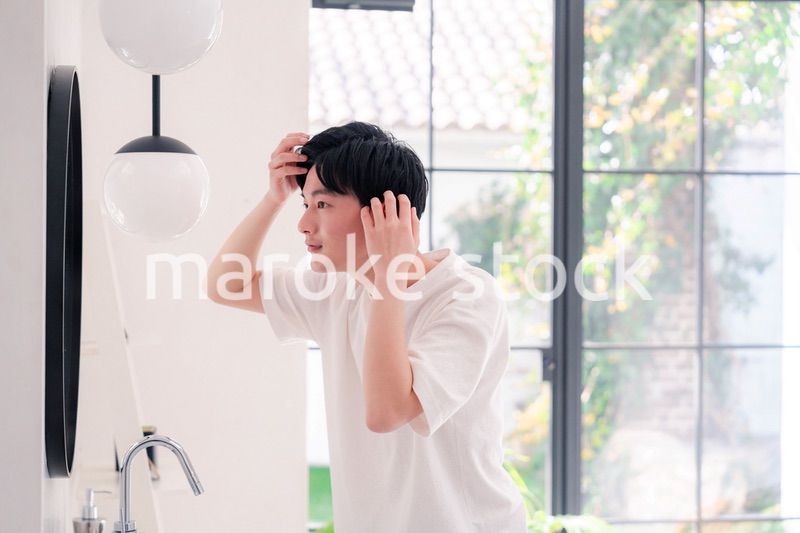 洗面所で身だしなみを整える若い男性