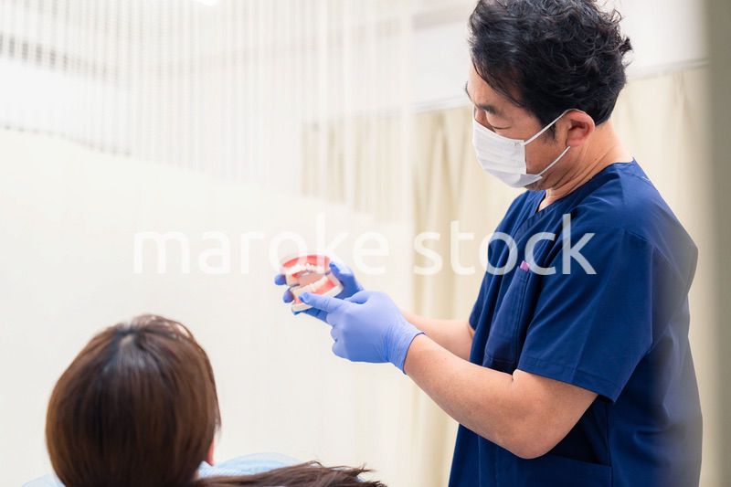 患者に治療方針を説明する歯科医師