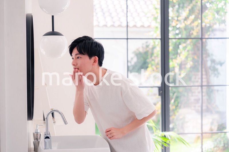 洗面所で身だしなみを整える若い男性