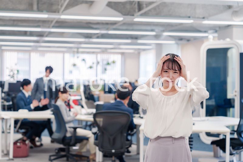 オフィスで頭を抱える女性従業員