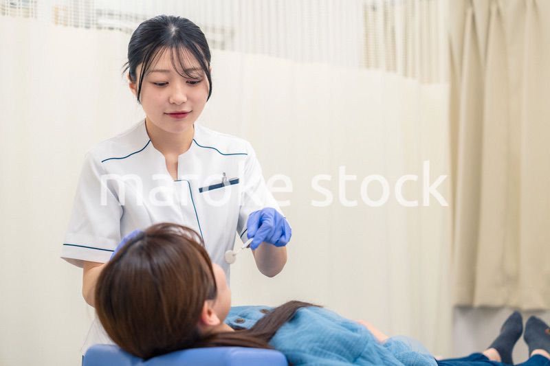 患者の歯のクリーニングをする歯科助手の女性