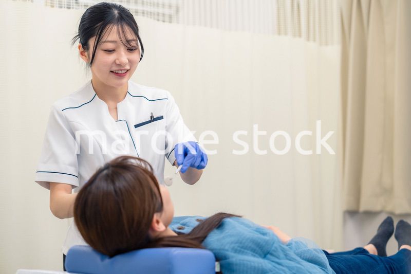 患者の歯のクリーニングをする歯科助手の女性