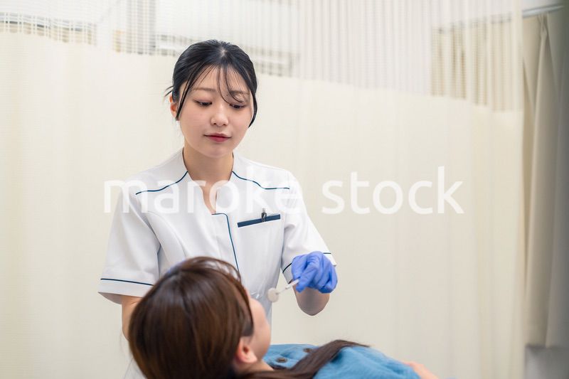 患者の歯のクリーニングをする歯科助手の女性