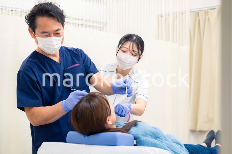 歯科治療をする歯医者の男性